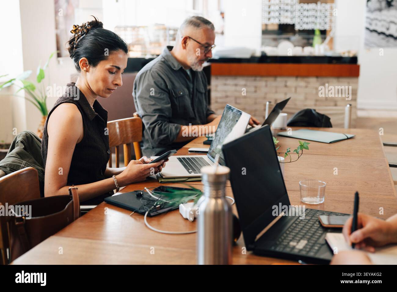 Businesswoman using smart phone during her work session at shared workspace Stock Photo