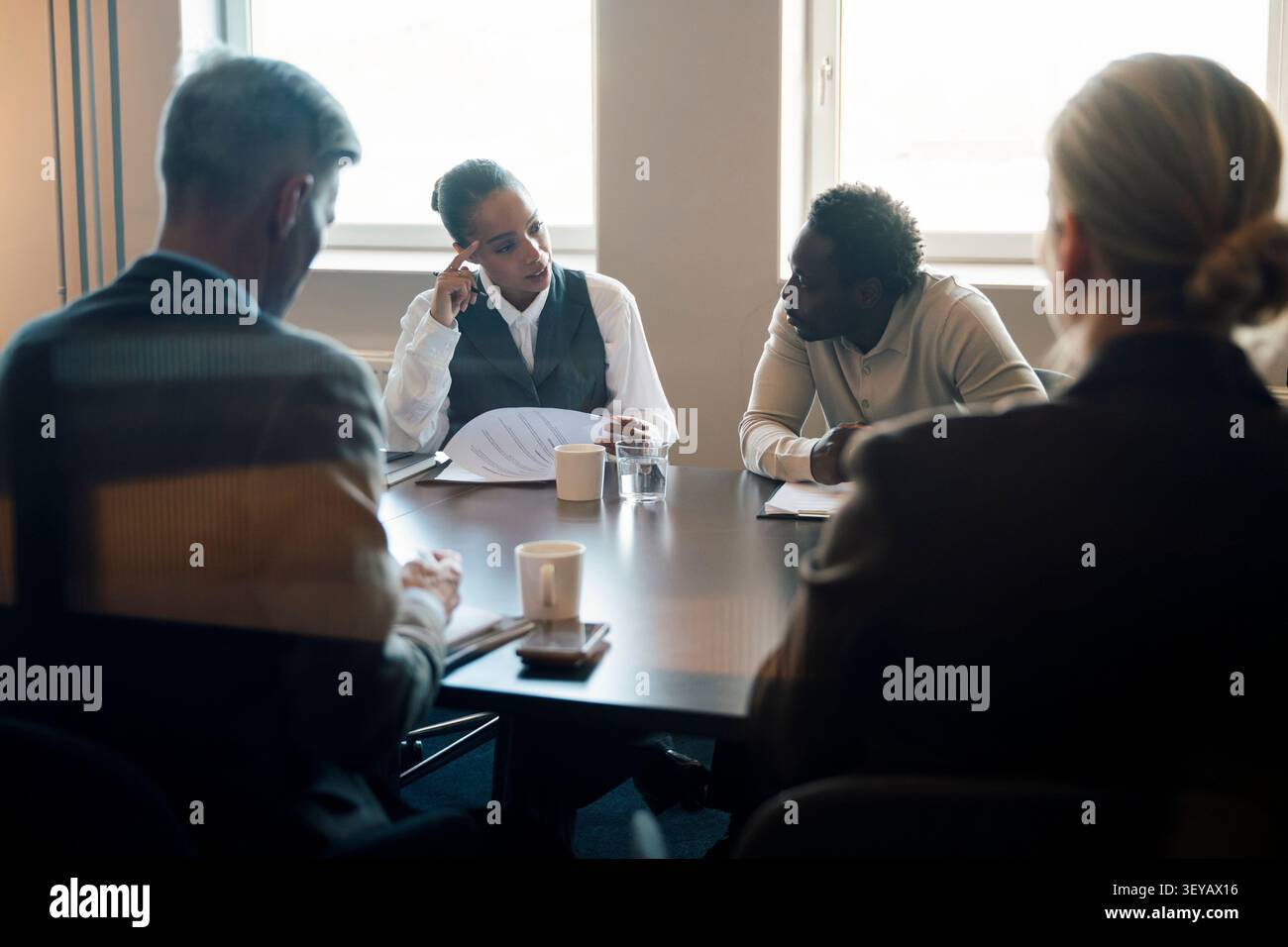 Group of corporate workers having serious conversation at work Stock Photo
