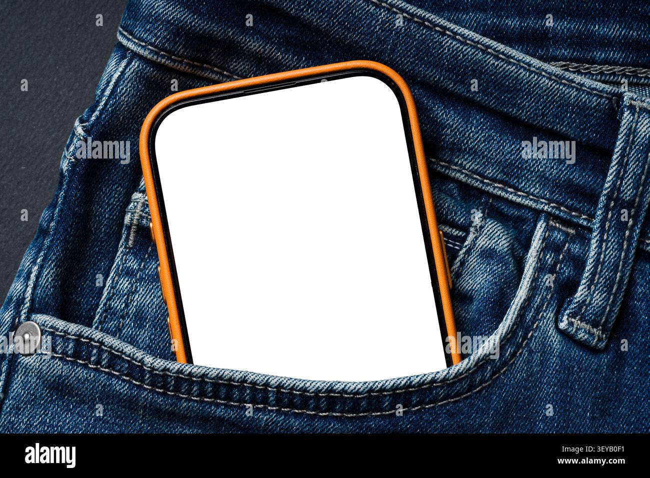 Blank smartphone screen in blue jeans pocket with orange case Stock Photo