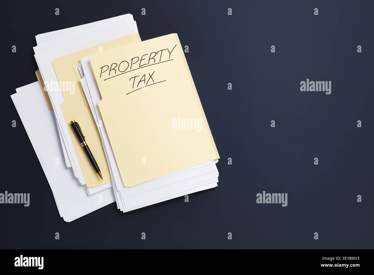 Property tax. Folders with papers on dark background, top view. Space for text Stock Photo