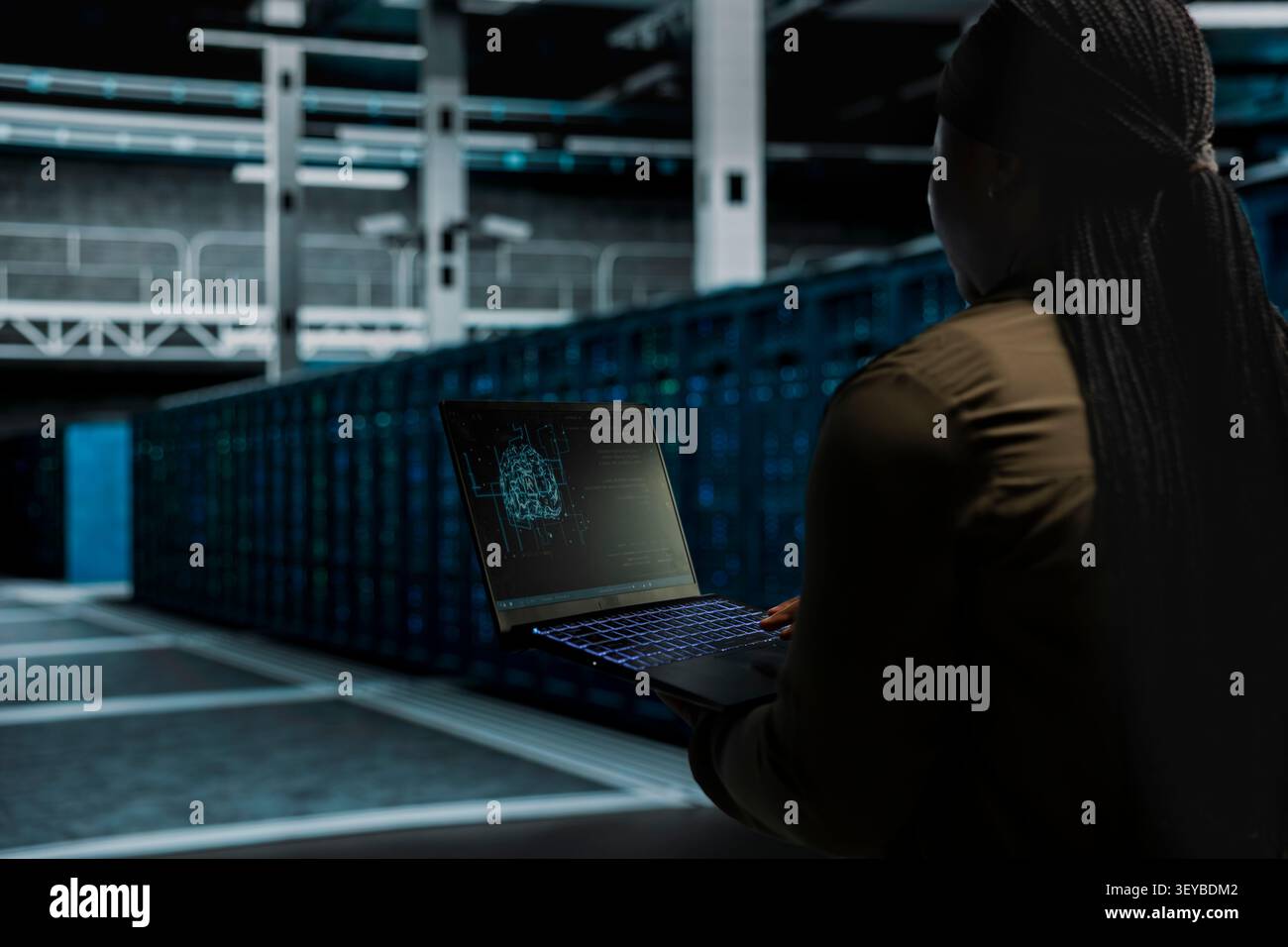 Computer scientist works with a computer workstation in a server hub to support artificial intelligence systems. Stock Photo