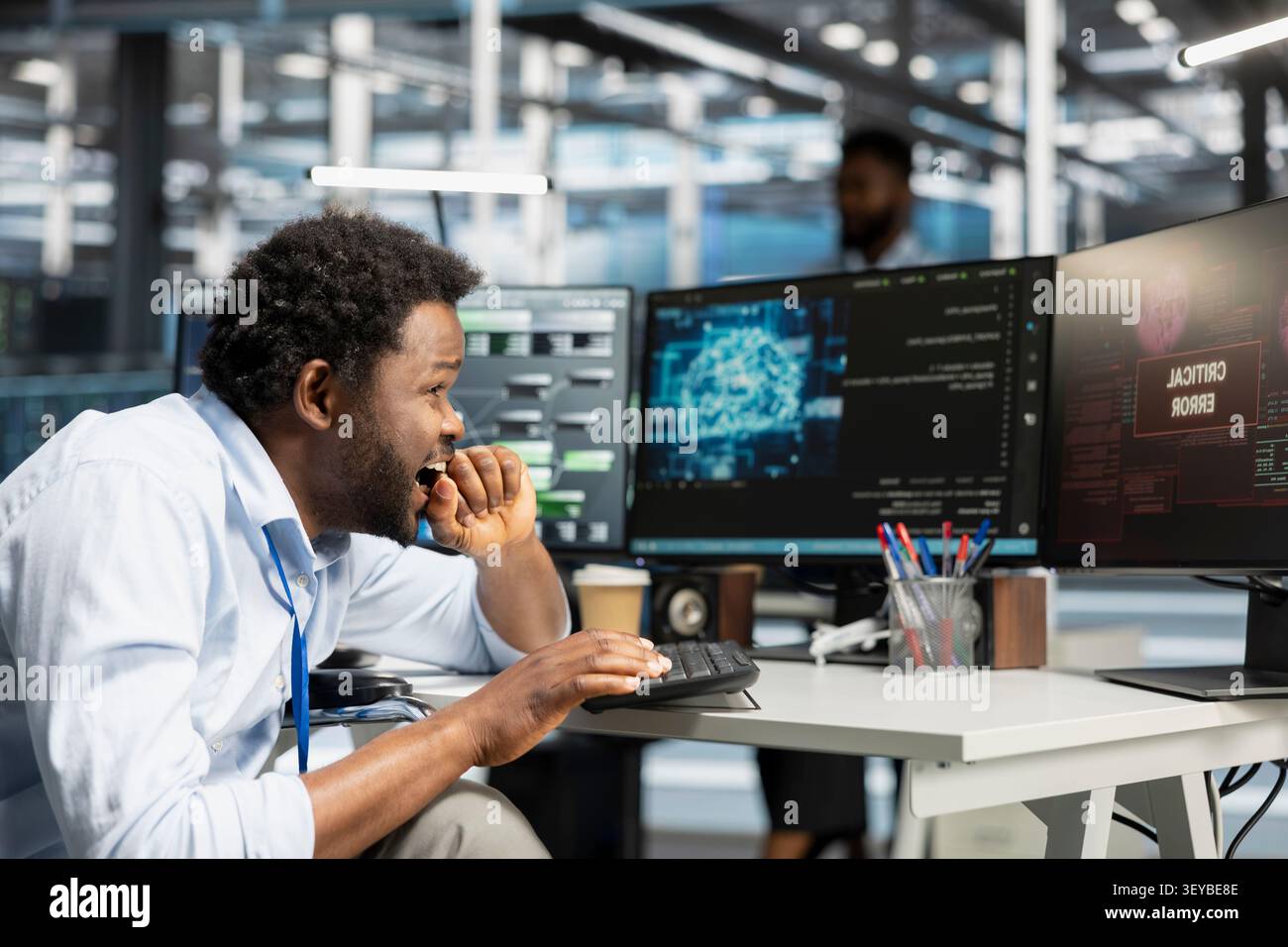 Data center administrator uses a computer to write code for AI systems, working with AI technology and high performance systems. Stock Photo