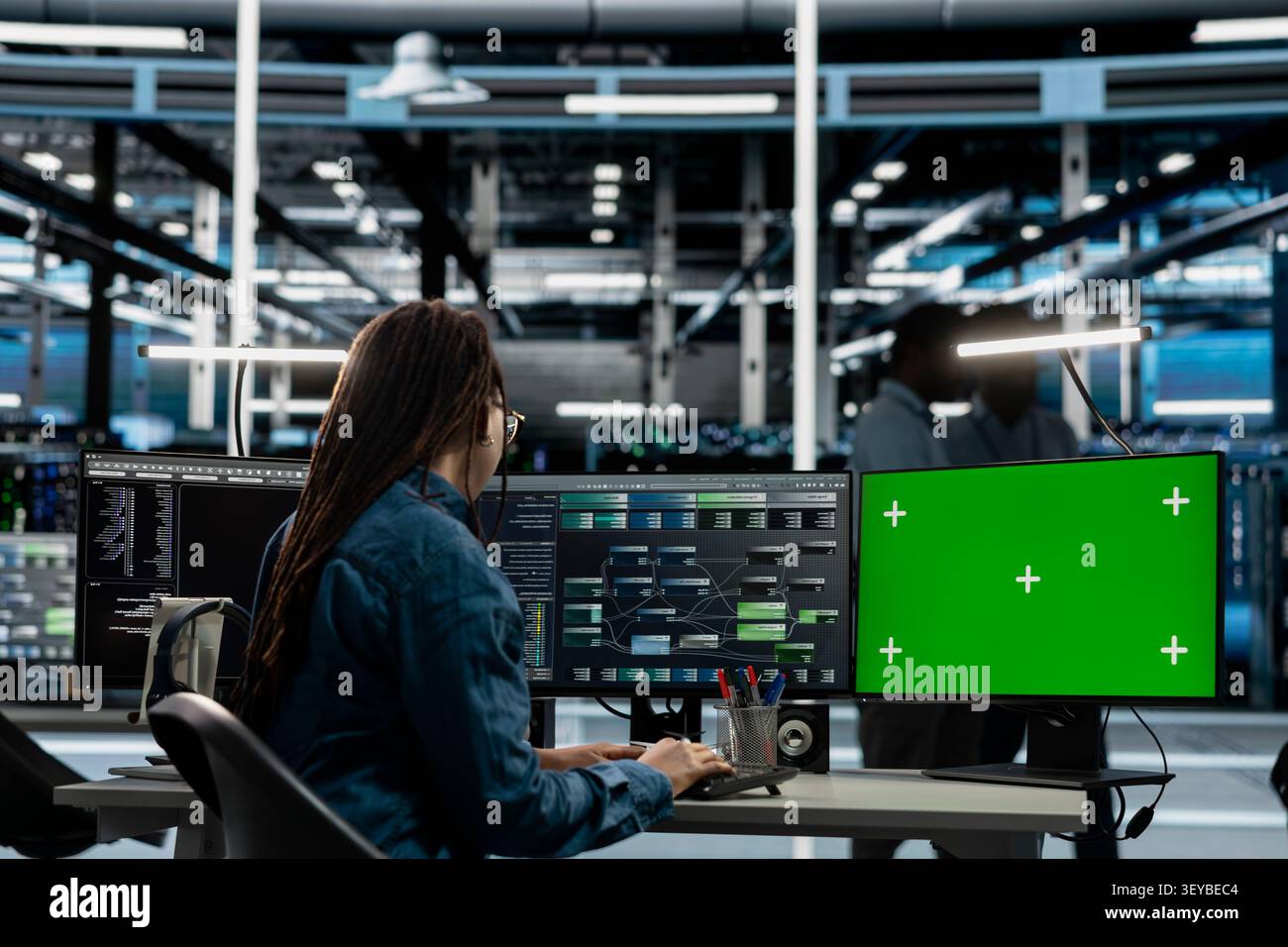 Data center engineer works with a chroma key computer, using an editable screen to manage technical tasks. Stock Photo