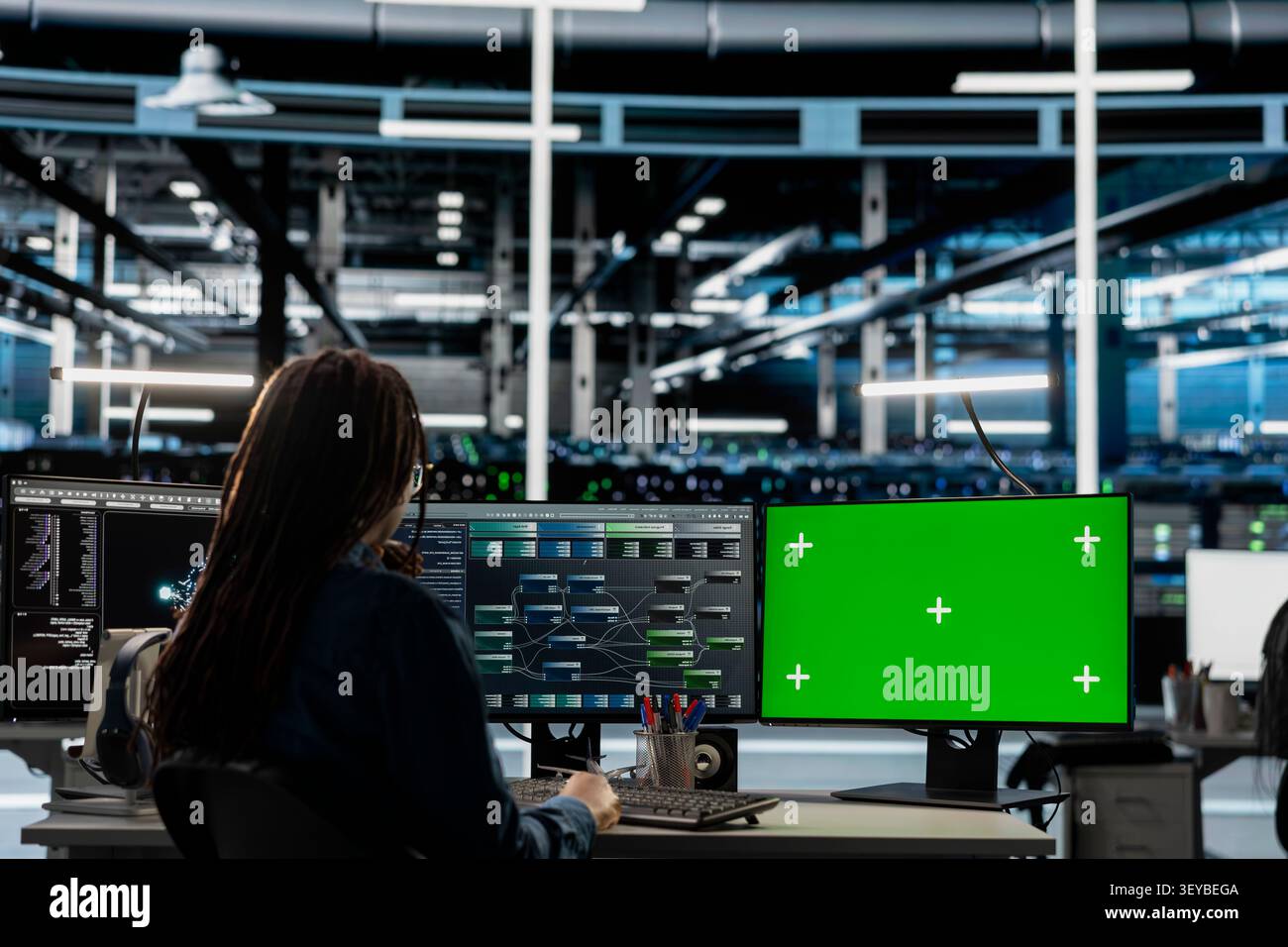 Data center engineer works with a chroma key computer, using an editable screen to review performance data. Stock Photo