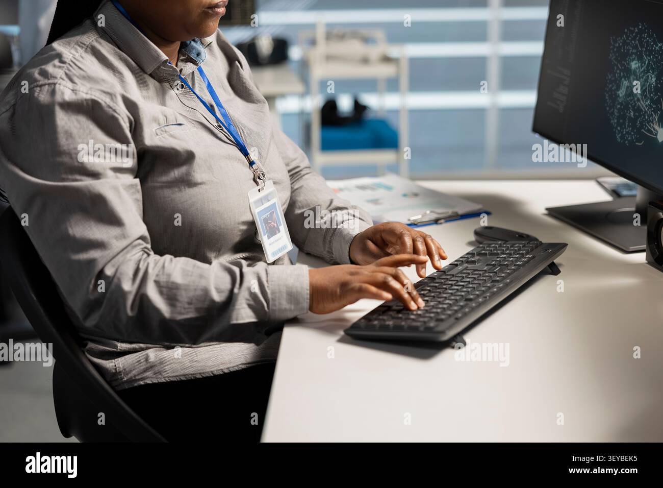 System administrator uses a computer to run diagnostics, update servers and check infrastructure performance. Stock Photo
