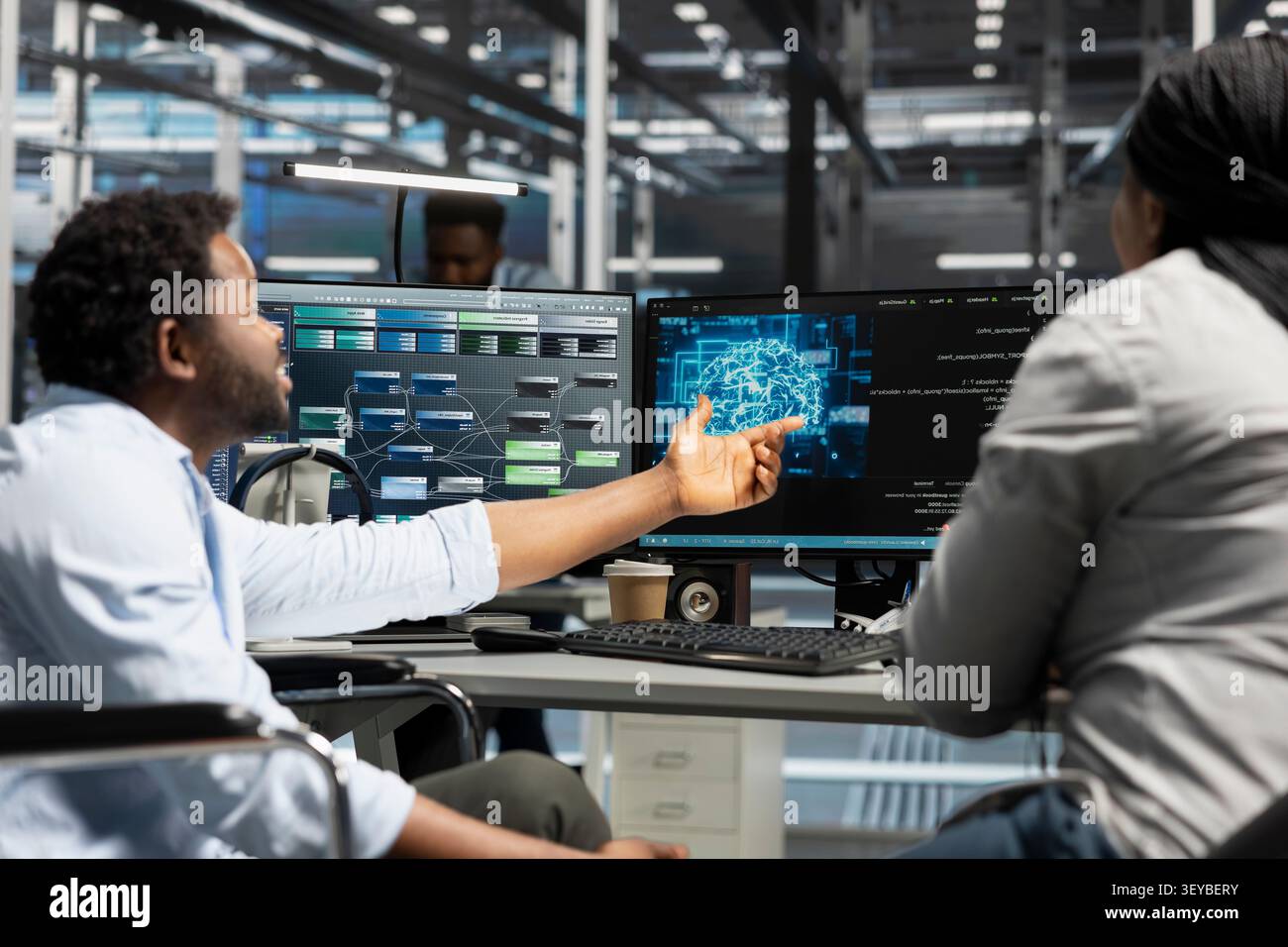 Data center engineer using a wheelchair uses a computer to manage machine learning workloads, working with AI technology and high performance systems. Stock Photo