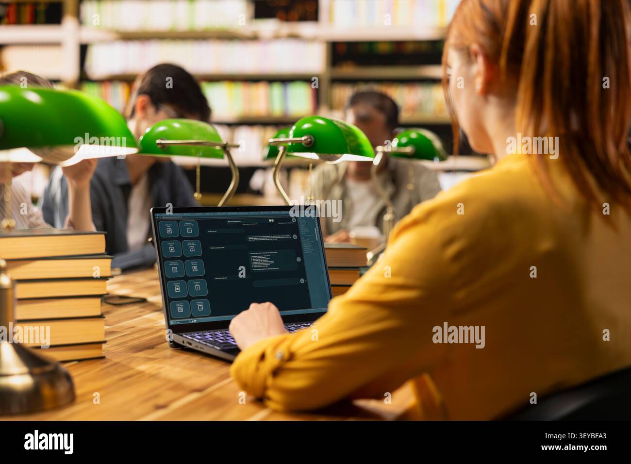 Student using AI study assistant interface on laptop during group study session in library, showcasing modern education with generative AI tools. Learning scene with classmates at table. Stock Photo