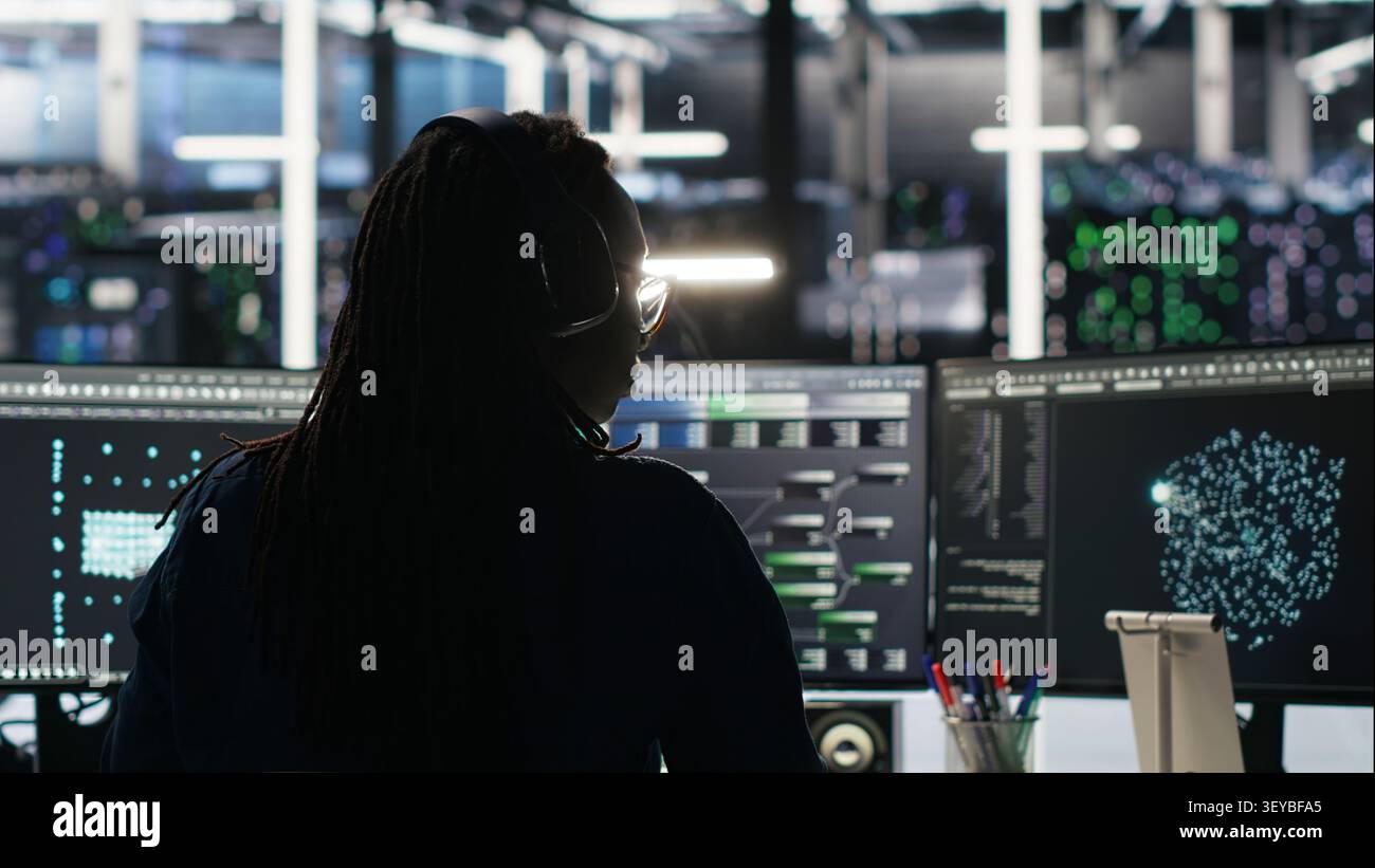 Data center programmer reviews artificial intelligence systems and machine learning processes inside a data center. Stock Photo