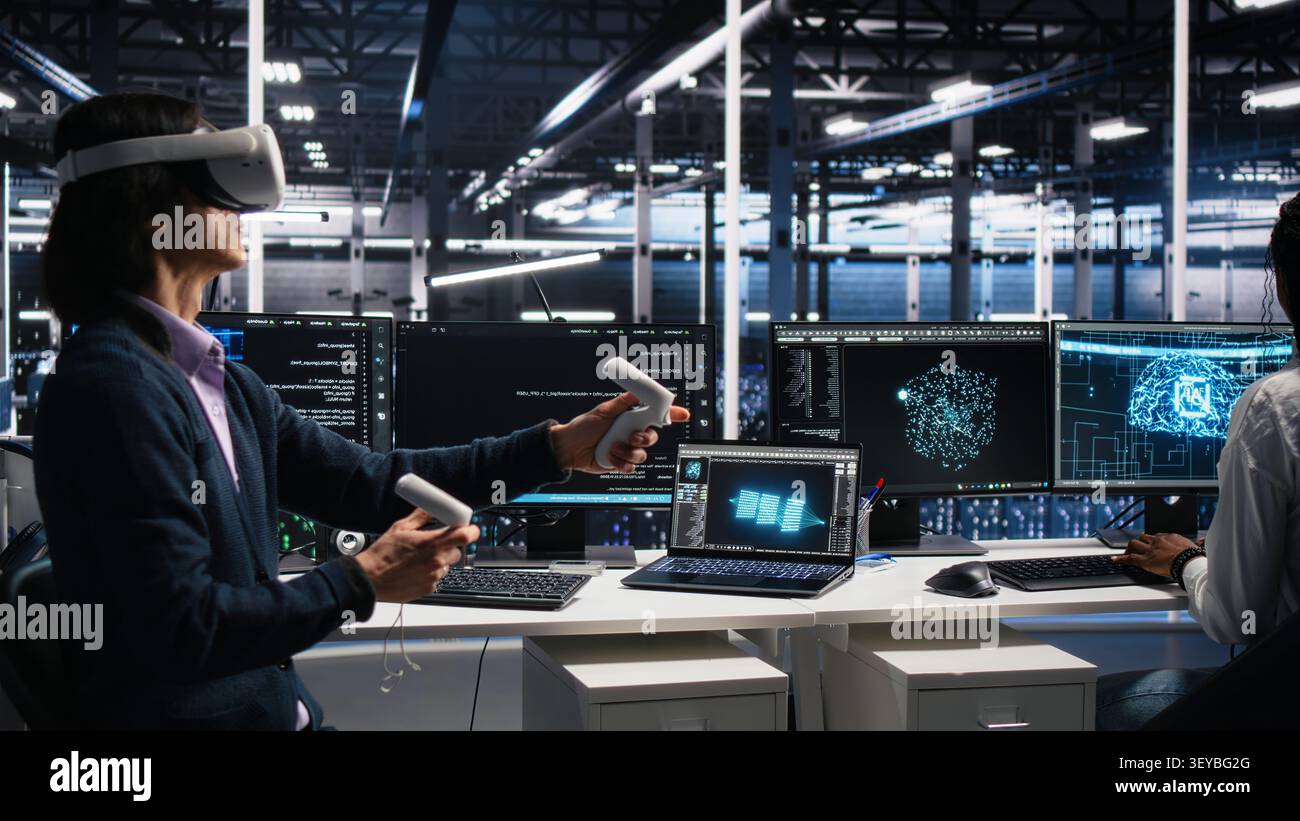 Software programmer working with virtual reality headset in data infrastructure center. Stock Photo