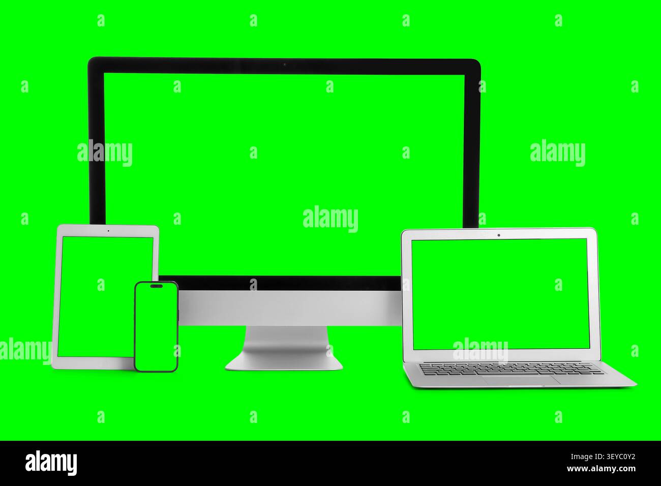Multiple digital devices with green screens on green background Stock Photo