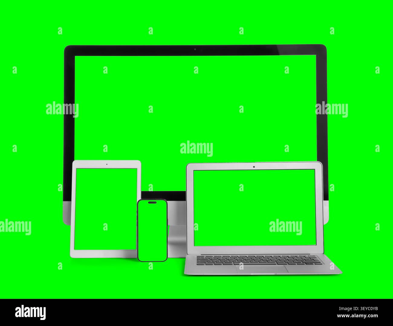 Multiple digital devices with green screen displays Stock Photo