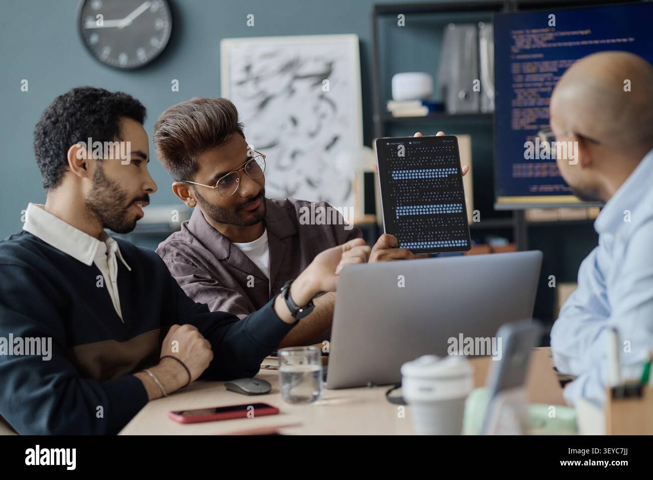 Multiethnic Men Reviewing Software Code in Information Technology Office Stock Photo
