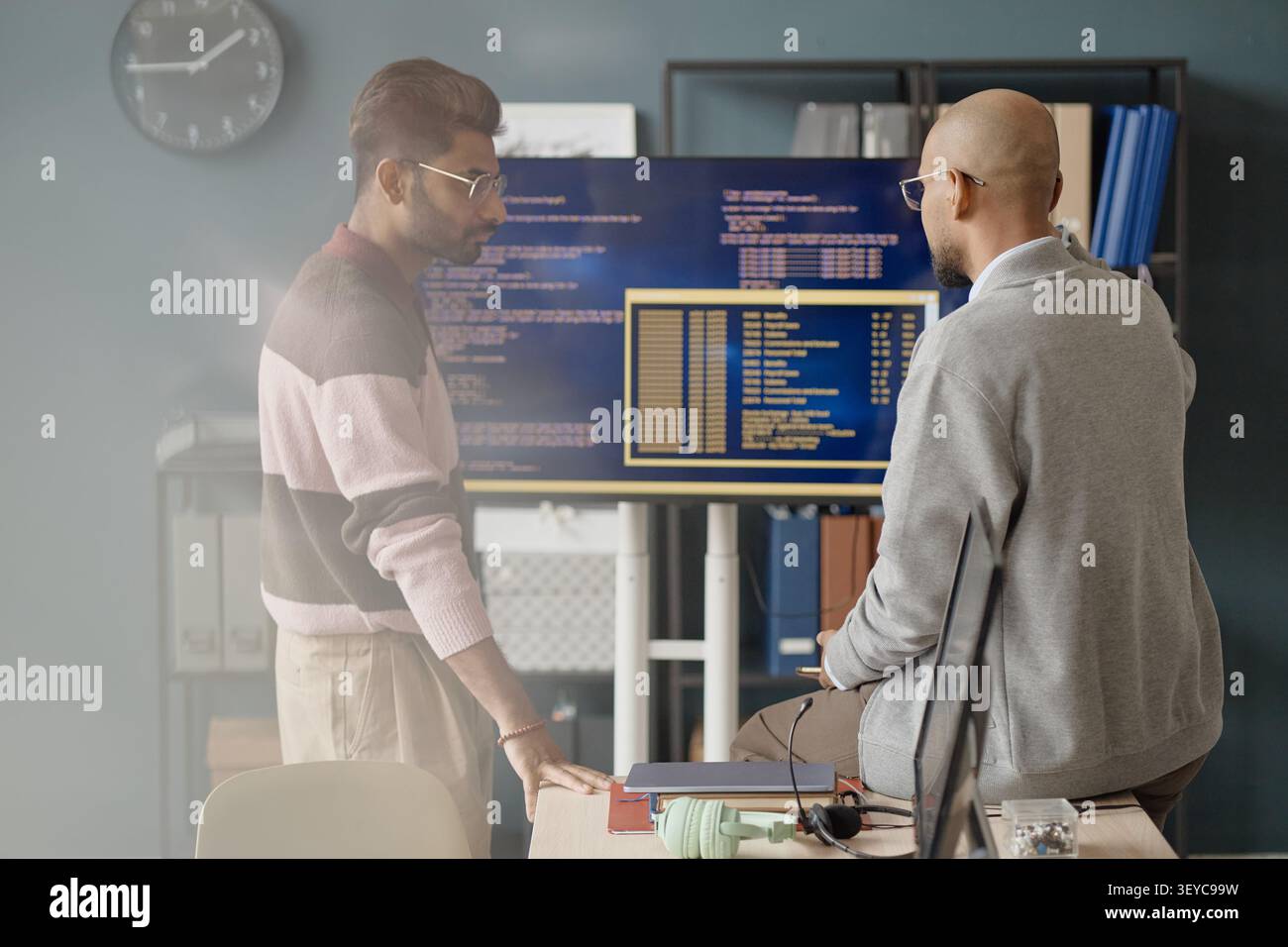 Adult Men Reviewing Software Code on Monitors in it Office Stock Photo