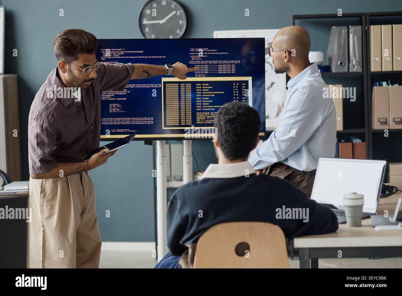 Diverse Men Reviewing Software Data during IT Office Meeting Stock Photo