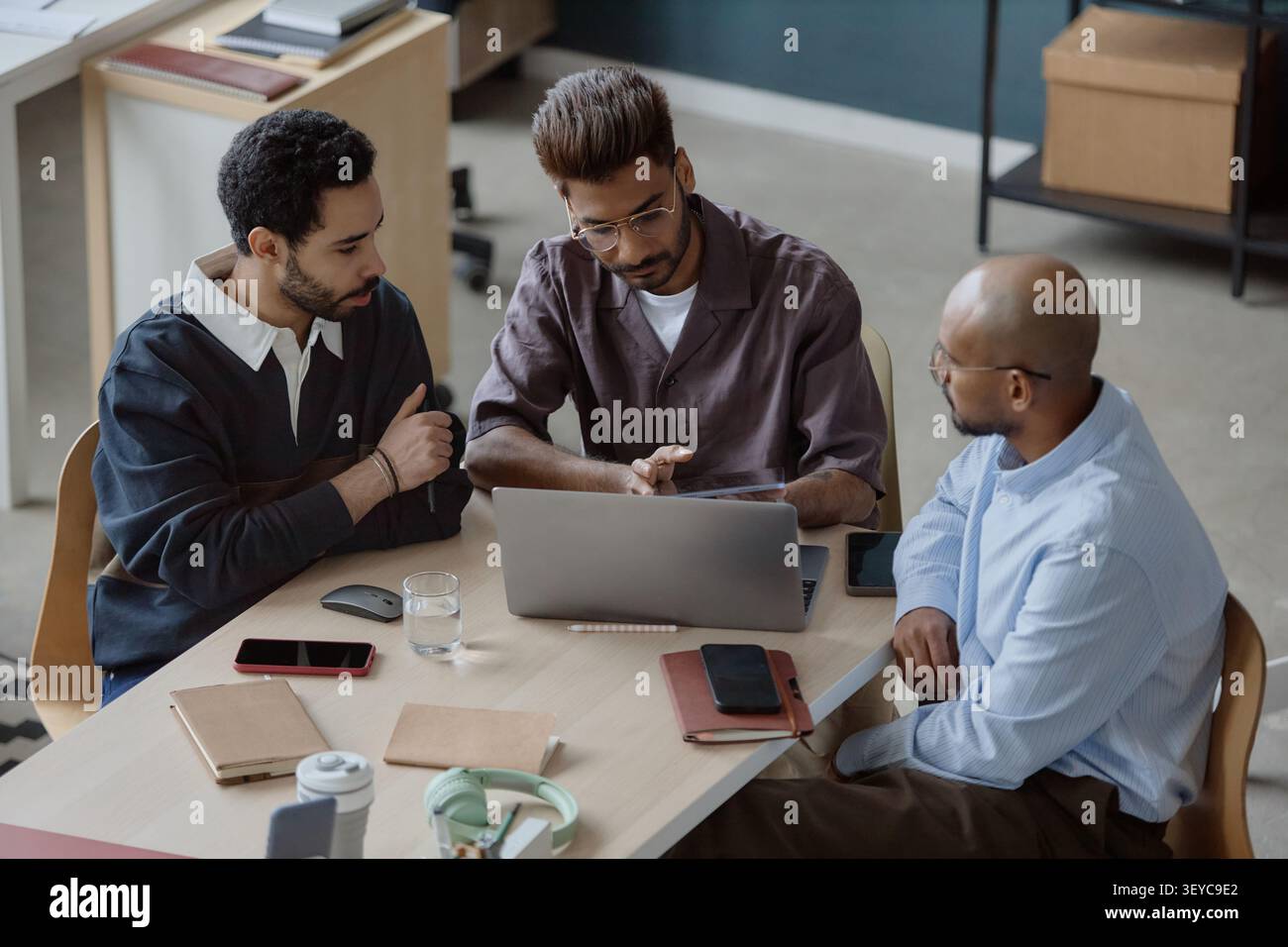 Diverse Businessmen Collaborating on Project in Office Stock Photo