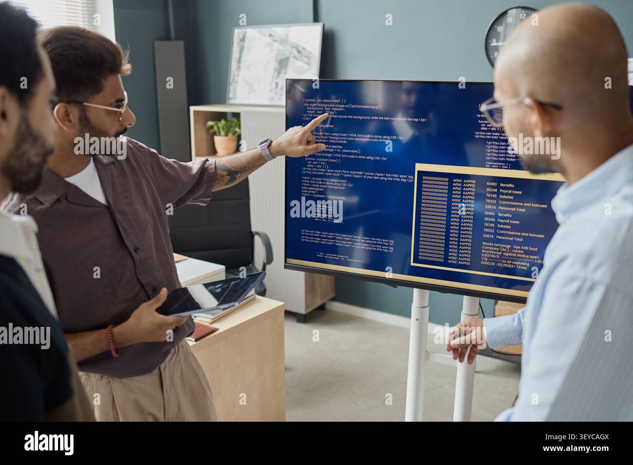 Diverse Men Reviewing Software Code in Information Technology Office Stock Photo