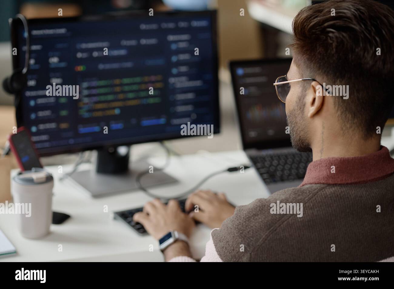 Adult Man Coding at Workstation in Information Technology Office Stock Photo