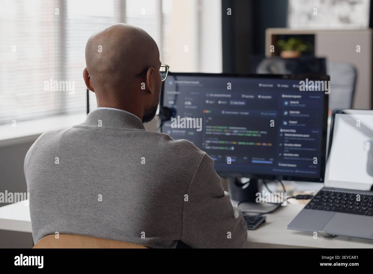 Man Coding at Desktop Computer in Information Technology Office Stock Photo