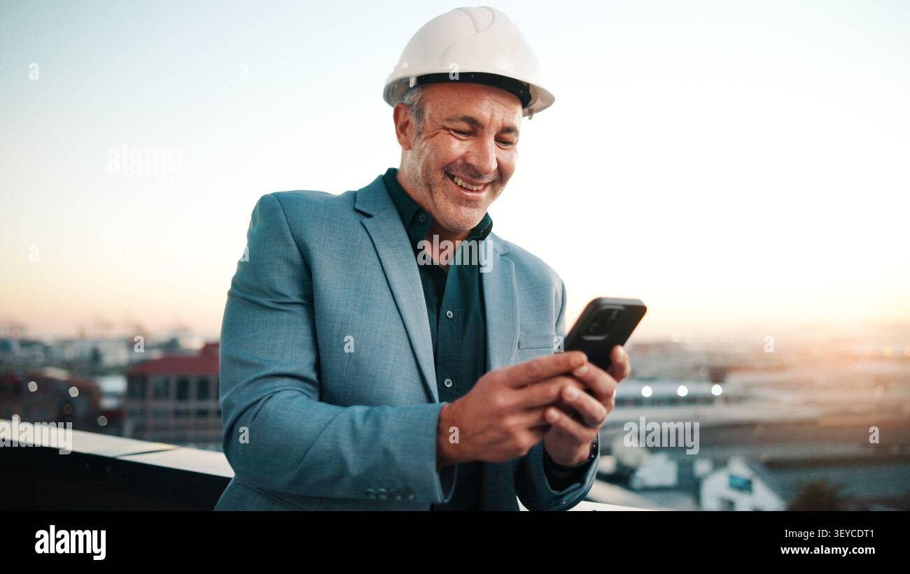 Typing, man and architect with phone, sunset and engineering for urban infrastructure outdoor. Communication, mature person and contractor on rooftop Stock Photo