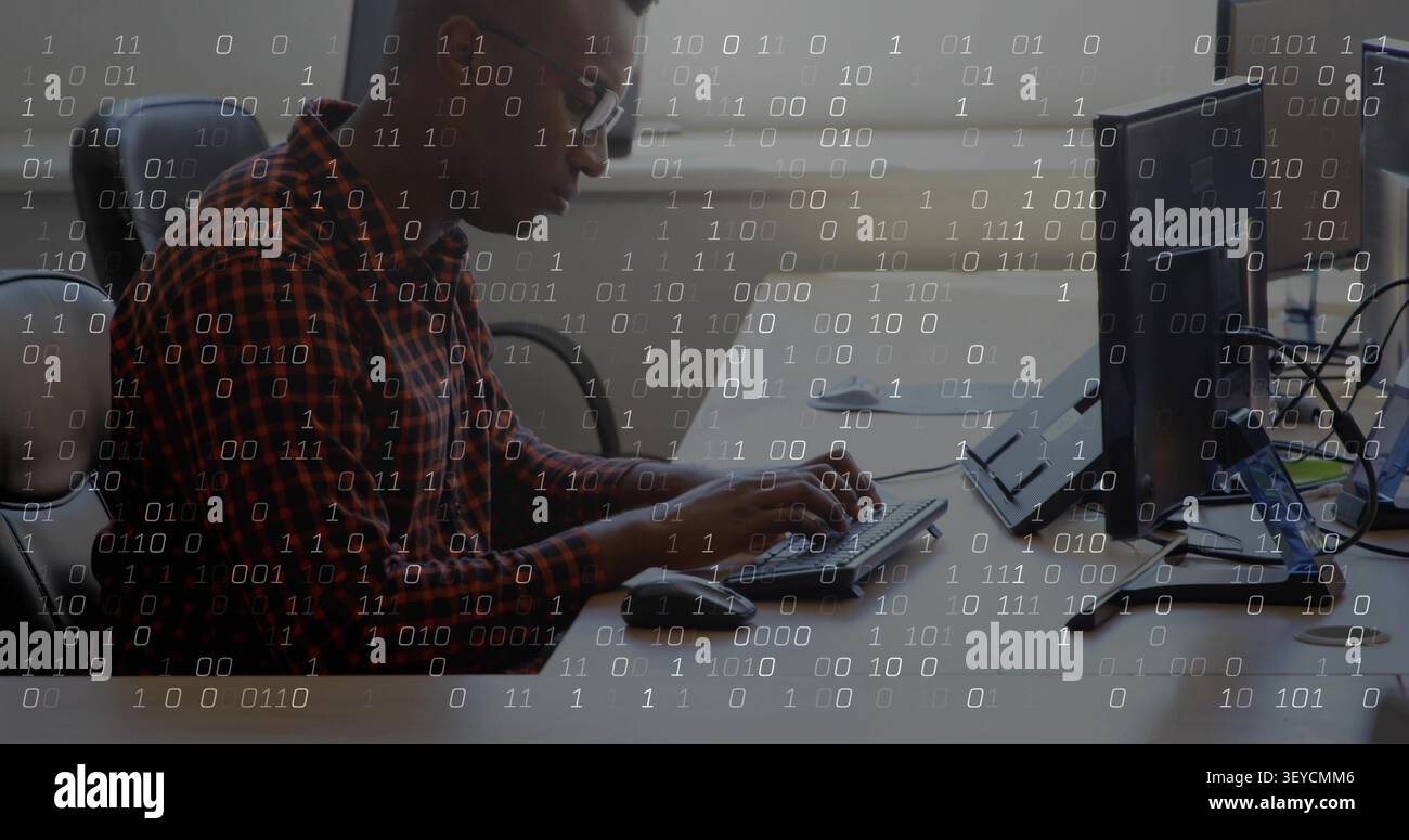 Man placing hands on keyboard, coding and leaning forward at tech desk, binary overlay appearing Stock Photo