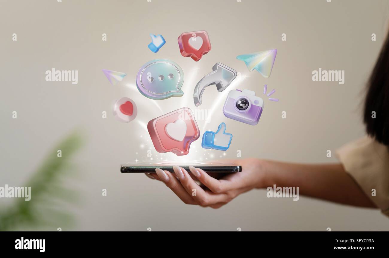 Cropped hand holding smartphone with floating 3D social media icons for digital marketing and online communication Stock Photo