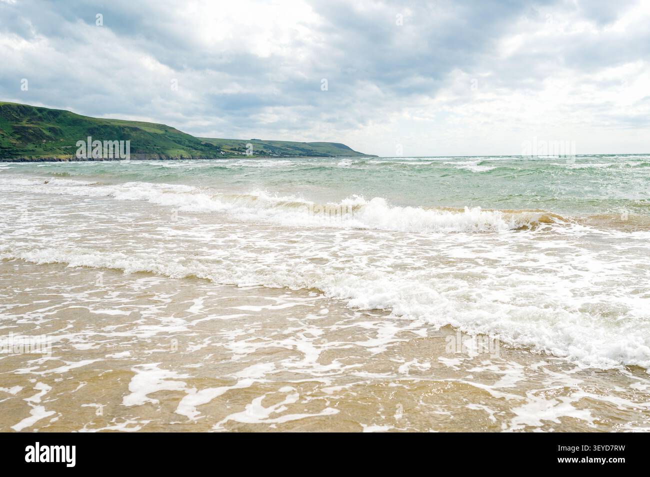 Waves rolling onto a quiet sandy beach Stock Photo