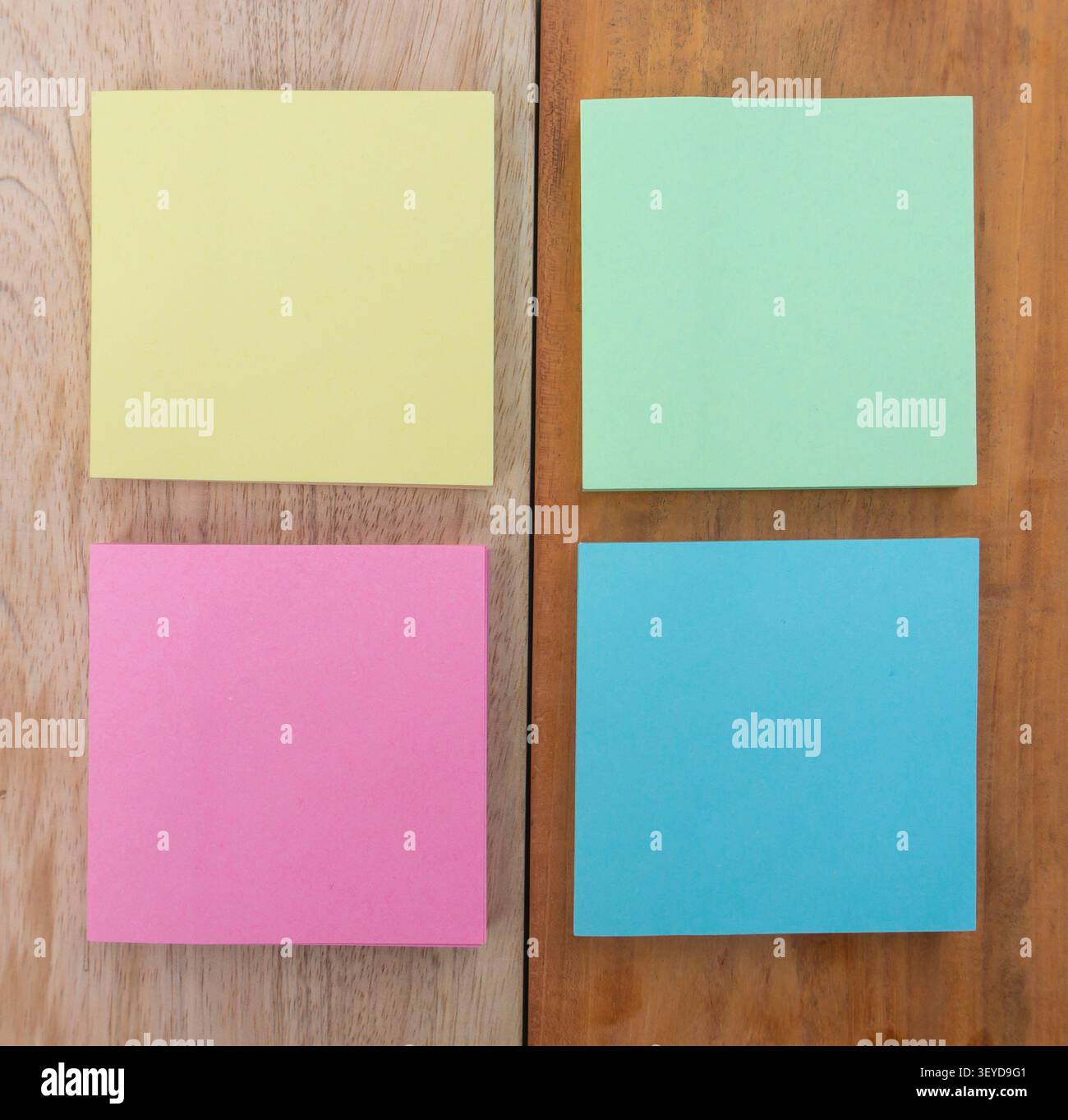 Four Pastel Sticky Notes on Wooden Board Stock Photo