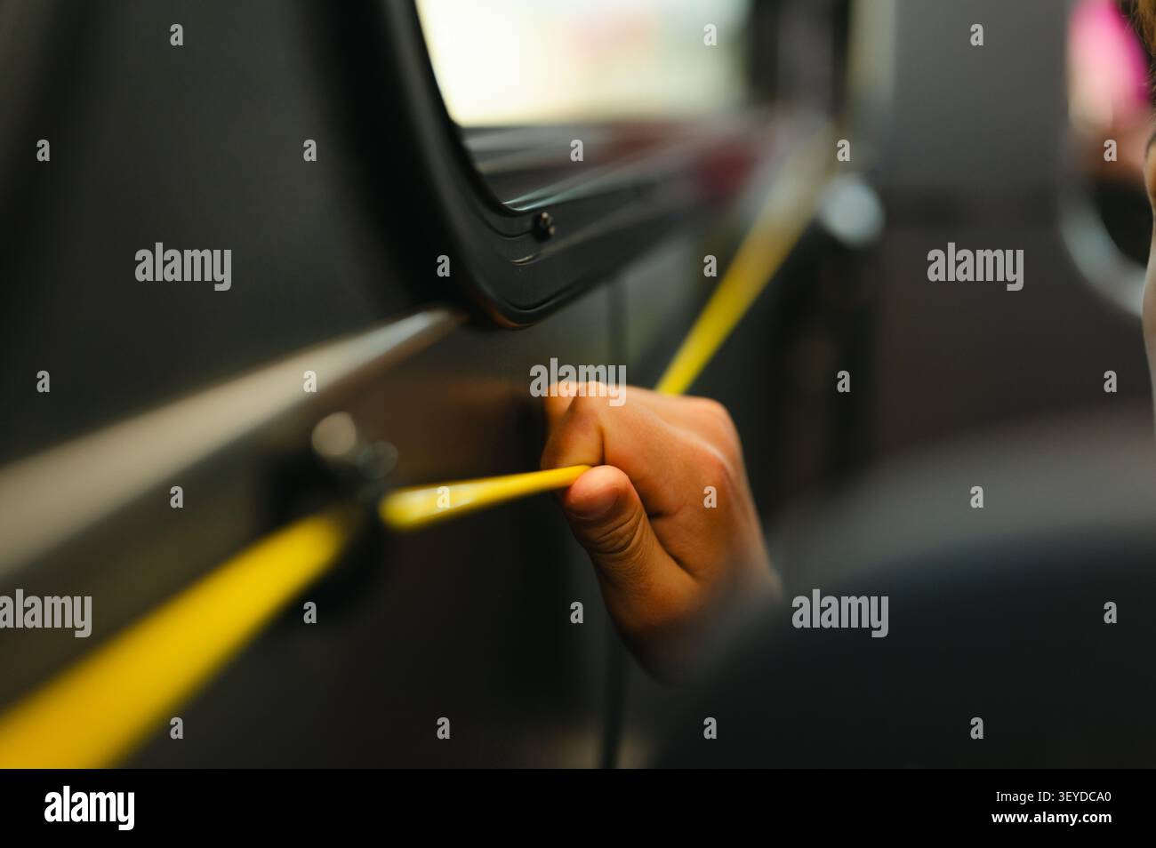 Passenger pulling bus stop request cord while riding the city bus Stock Photo