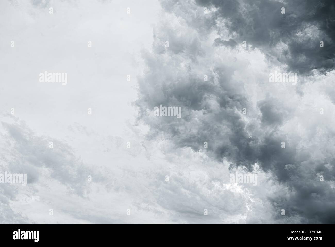 Dark storm clouds gather across a dramatic and overcast sky. Stock Photo