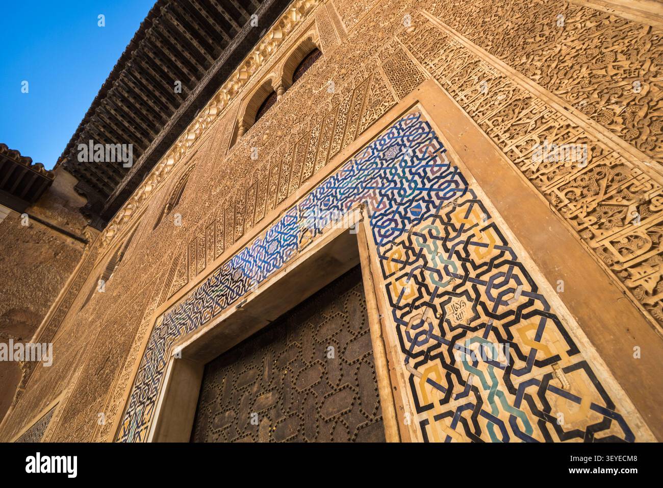 Intricate tile work and stucco carving on the wall and archway at the Alhambra in Granada, Andalusia, Spain Stock Photo