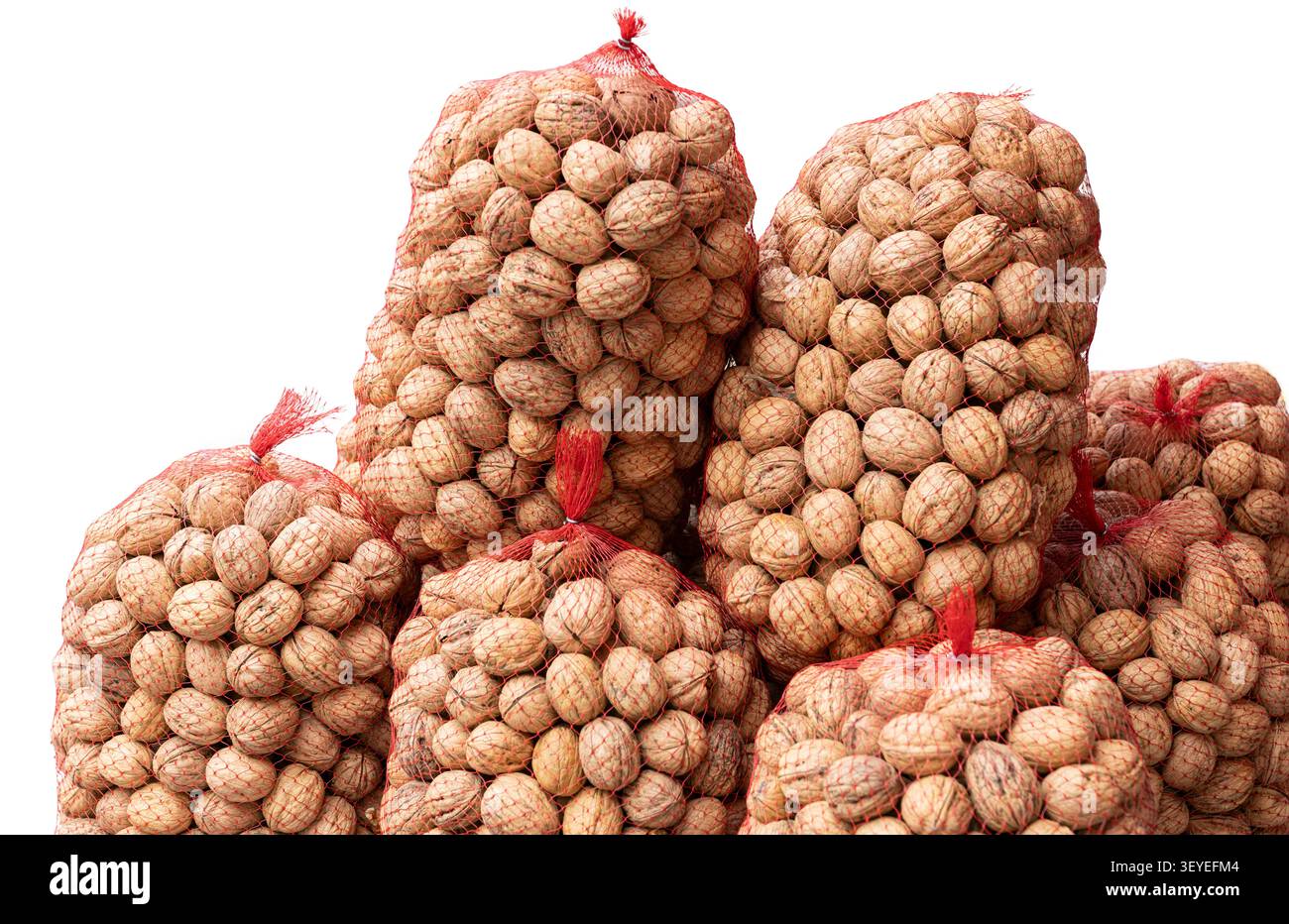 walnuts in red mesh sacks isolated on white background Stock Photo