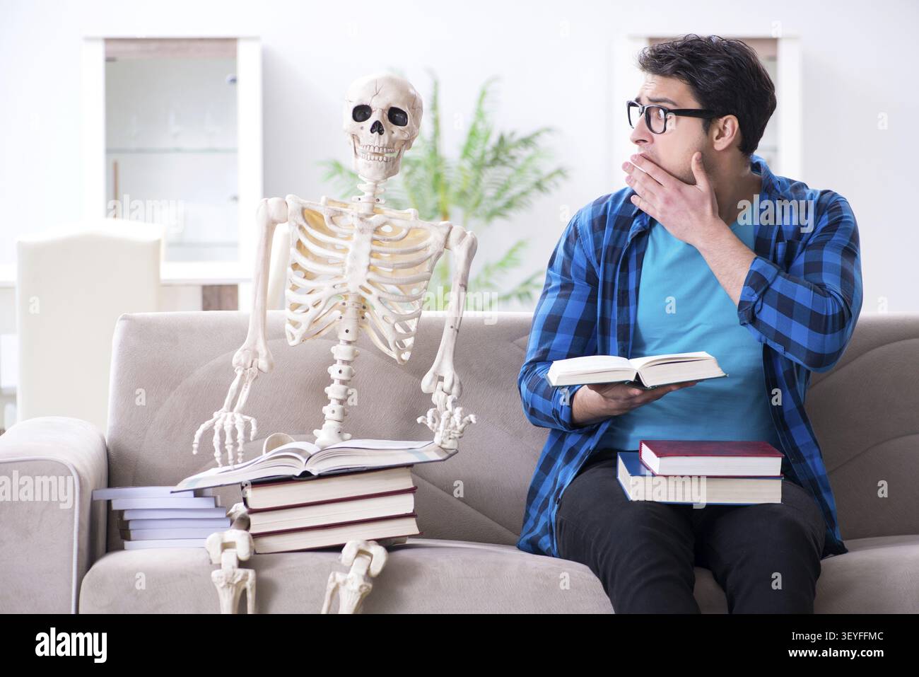 Student studying with skeleton preparing for exams Stock Photo