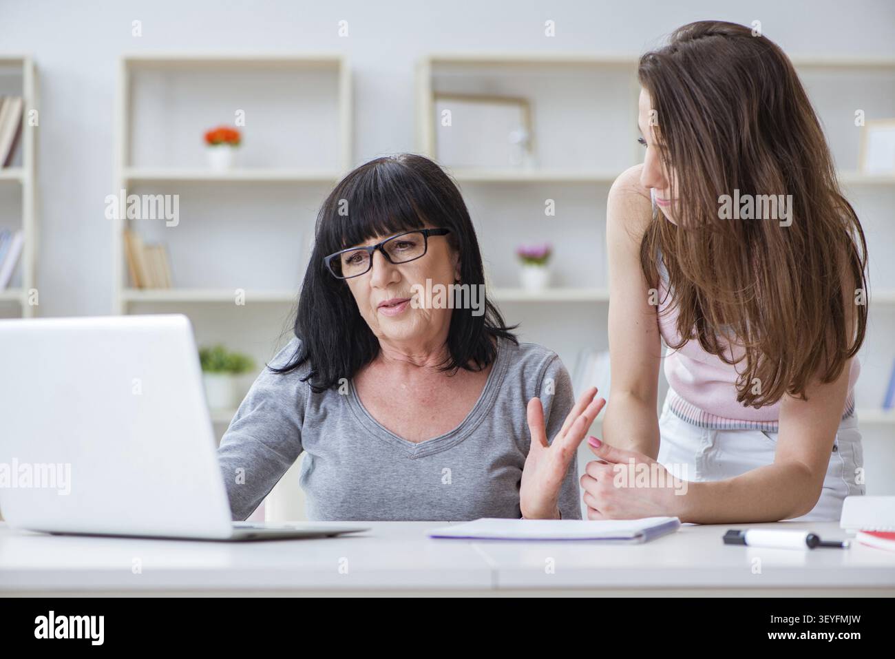 Daughter explaining to mom how to use computer Stock Photo