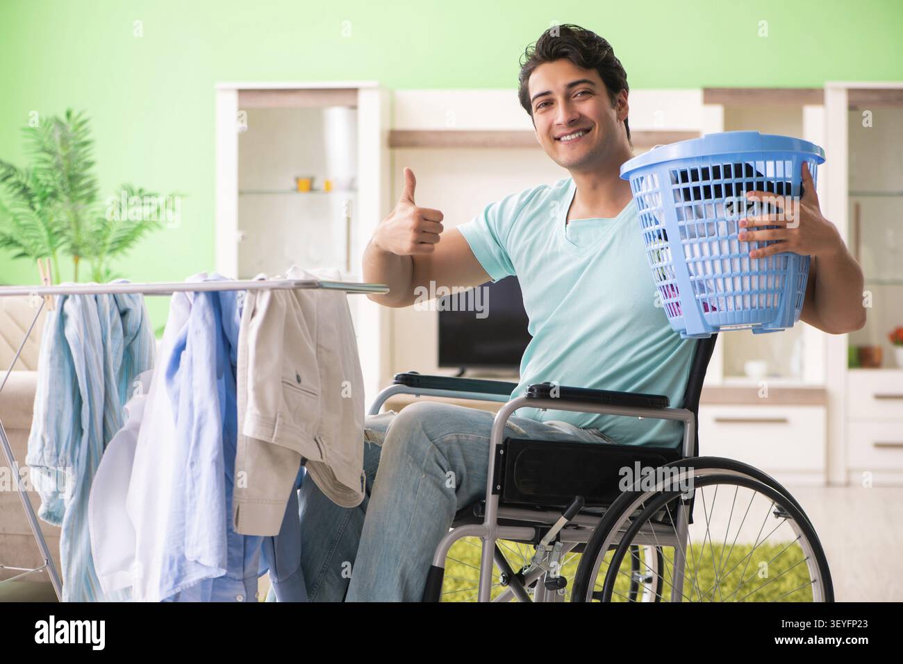 Disabled man on wheelchair doing laundry Stock Photo