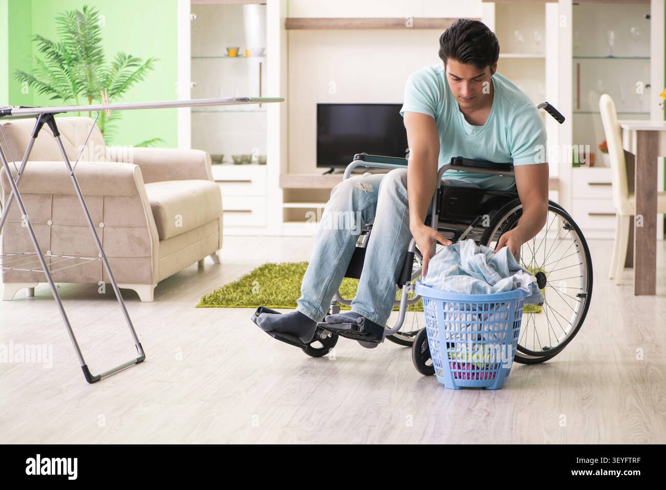 Disabled man on wheelchair doing laundry Stock Photo