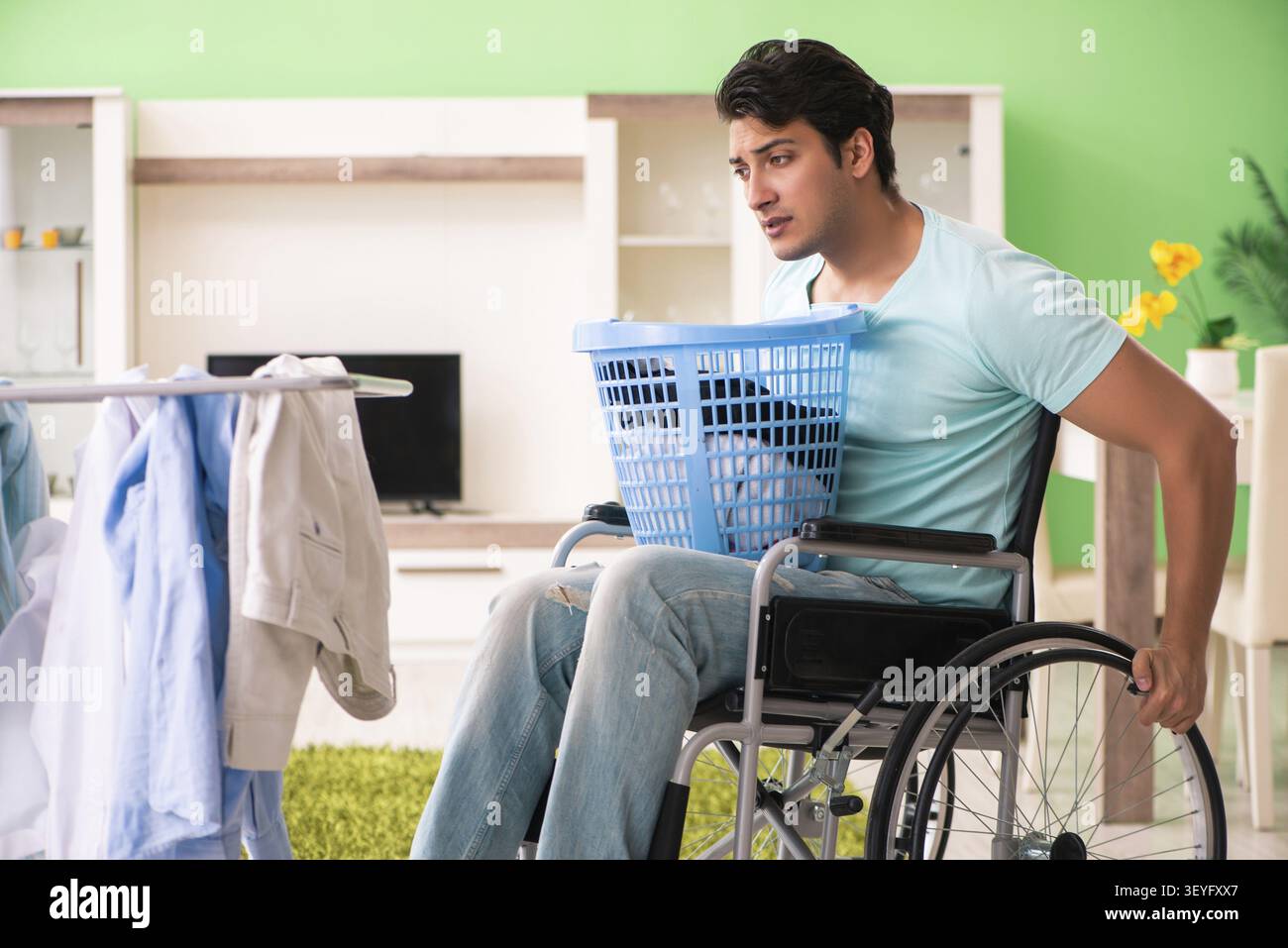 Disabled man on wheelchair doing laundry Stock Photo