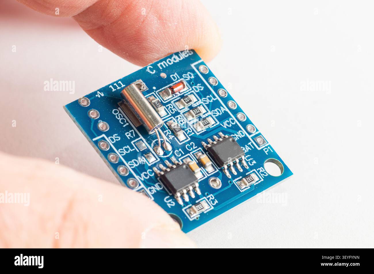 Real Time Clock Module For AVR ARM PIC Tiny RTC I2C modules memory DS1307 Clock in hand Stock Photo
