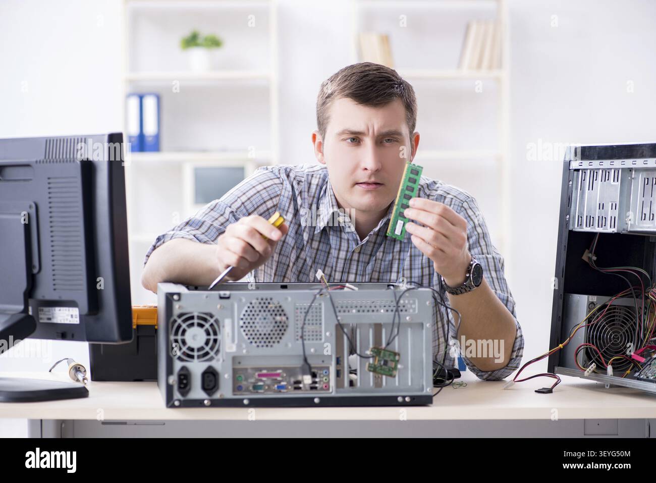 Young technician repairing computer in workshop Stock Photo