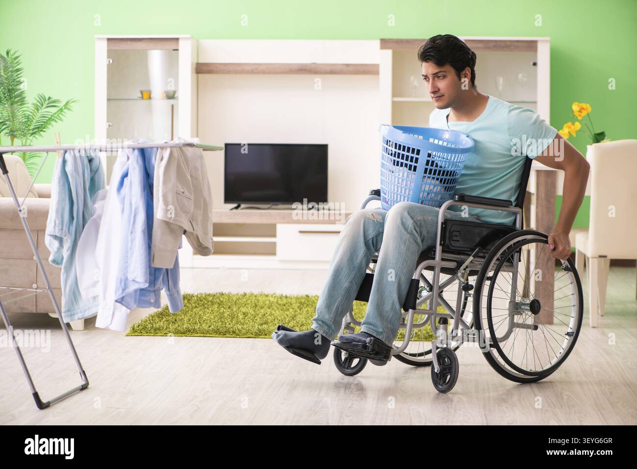 Disabled man on wheelchair doing laundry Stock Photo