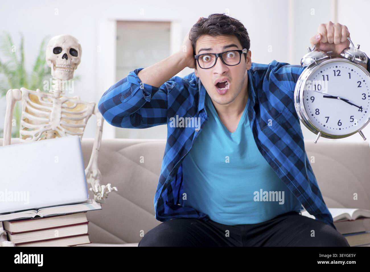 Student studying with skeleton preparing for exams Stock Photo