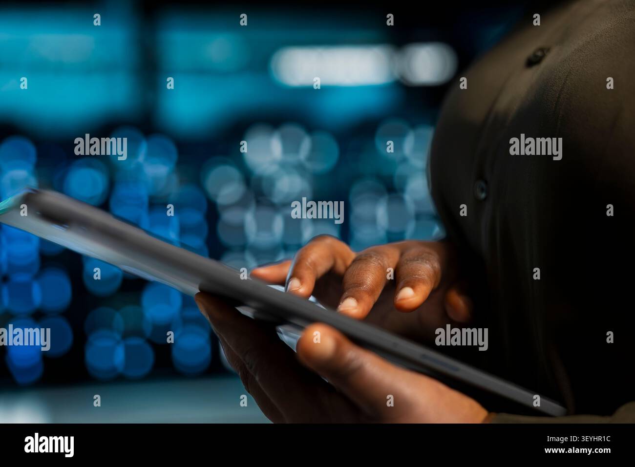 Data center programmer uses a tablet to install and configure equipment, supporting reliable infrastructure operations. Stock Photo