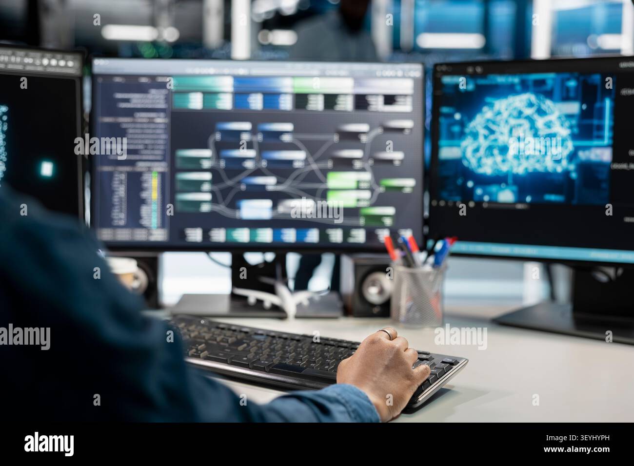Data center programmer uses a computer to manage machine learning workloads, working with AI technology and high performance systems. Stock Photo