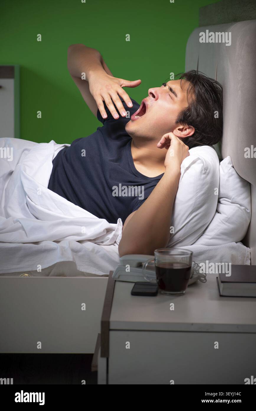 Young handsome man suffering from insomnia at home Stock Photo