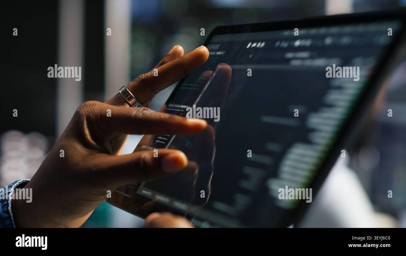 Data center programmer uses a tablet to update server software, supporting reliable infrastructure operations. Stock Photo