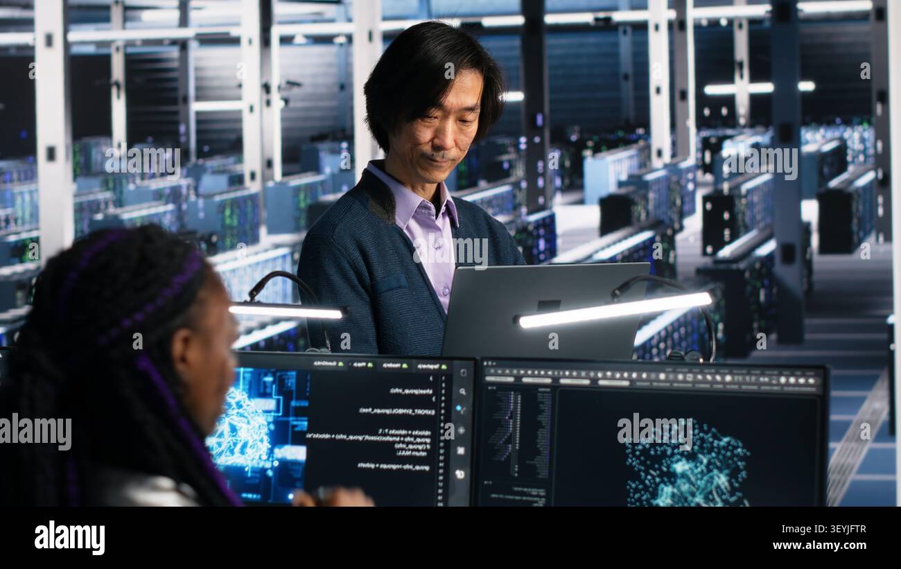 IT colleagues collaborate in a data center while reviewing AI diagnostics and infrastructure performance. Stock Photo