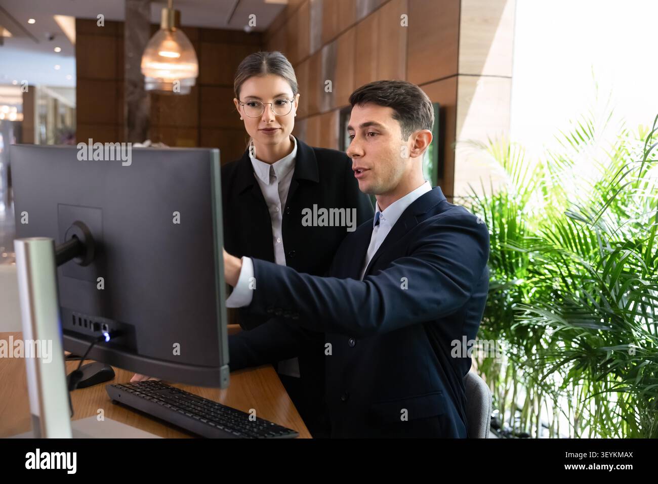 Two receptionists working together on administrative work task on computer Stock Photo