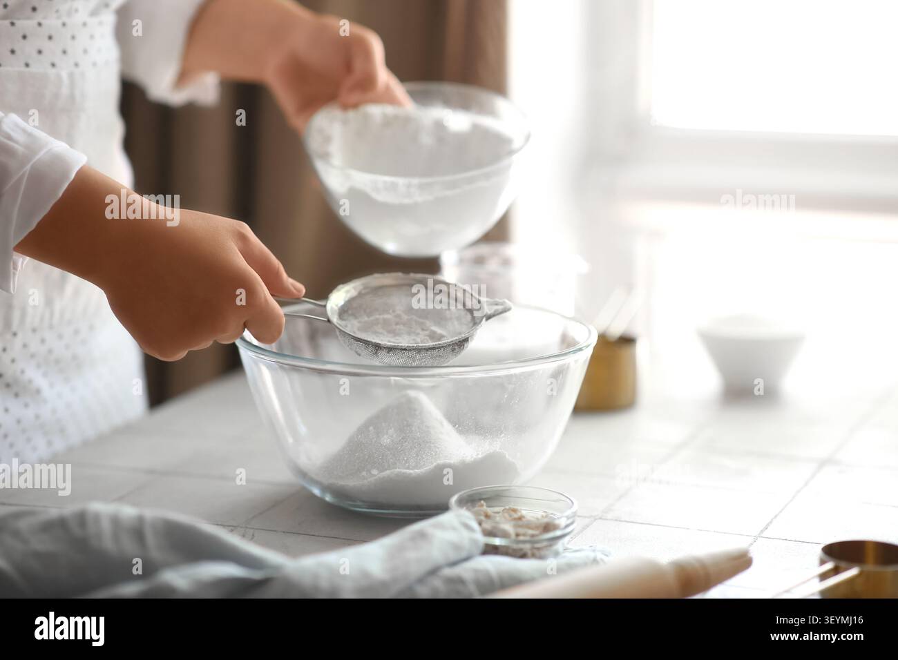 Woman preparing traditional cinnamon rolls in kitchen Stock Photo