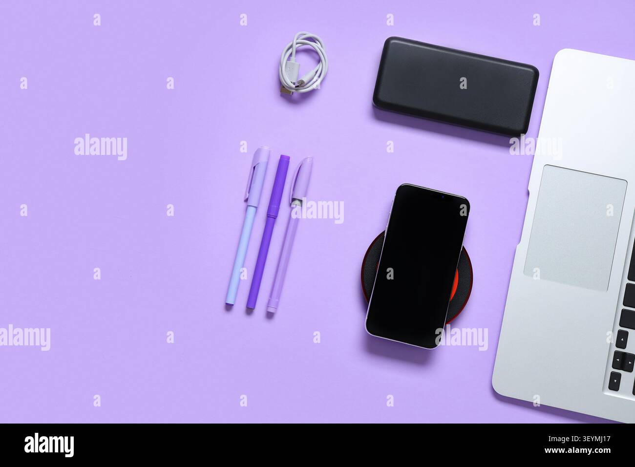 Composition with modern gadgets and pens on lilac background Stock Photo