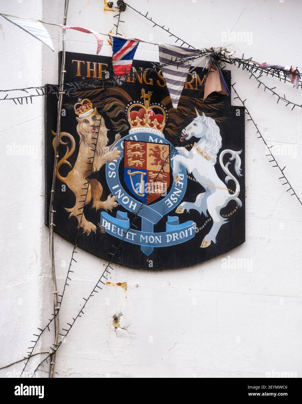 The "Dieu et Mon Droit" shield on the wall of King's Arms pub in the historic market town of Arundel, West Sussex, England Stock Photo