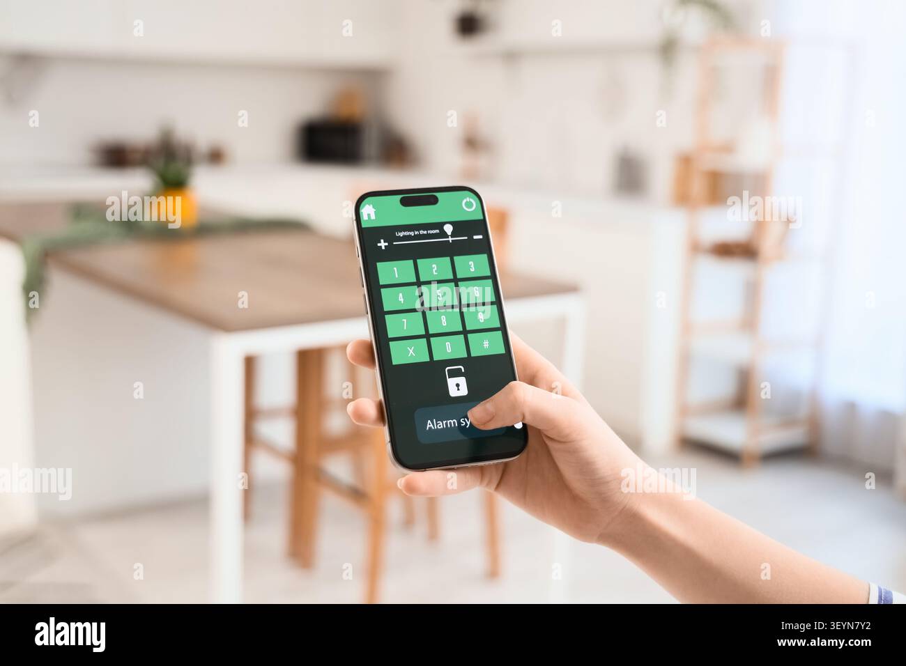 Person using smartphone app to control home alarm system Stock Photo